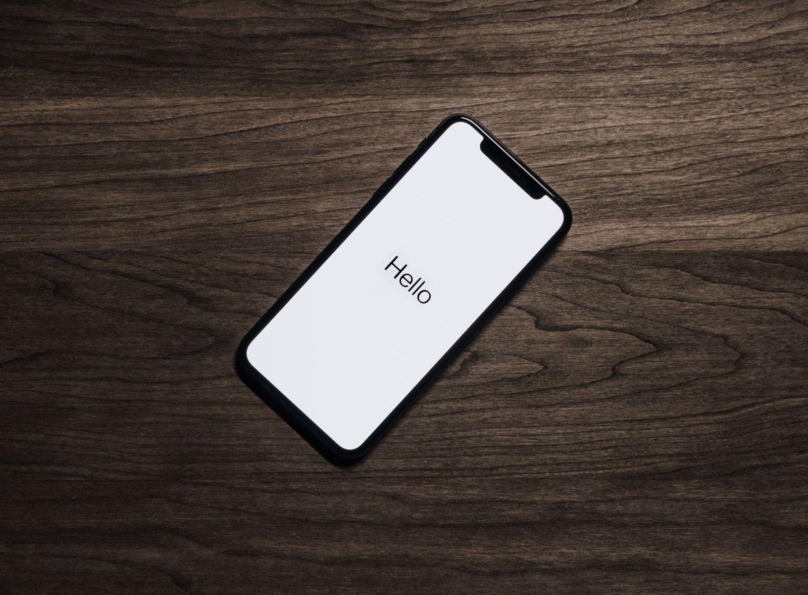 A phone saying hello on a wooden table